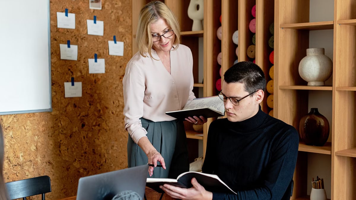 Professional team engaging in a collaborative meeting in a modern office space with notebooks.